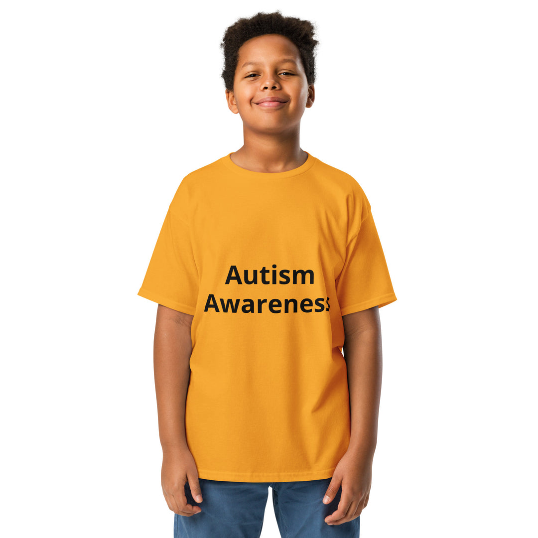 Kid wearing gold colored t-shirt with black wording “Autism Awareness”