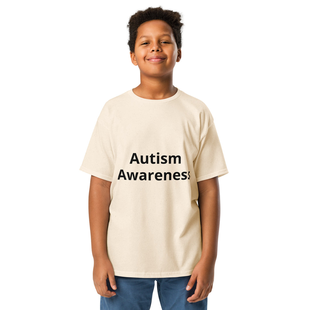 Kid wearing natural (cream) colored t-shirt with black wording “Autism Awareness”